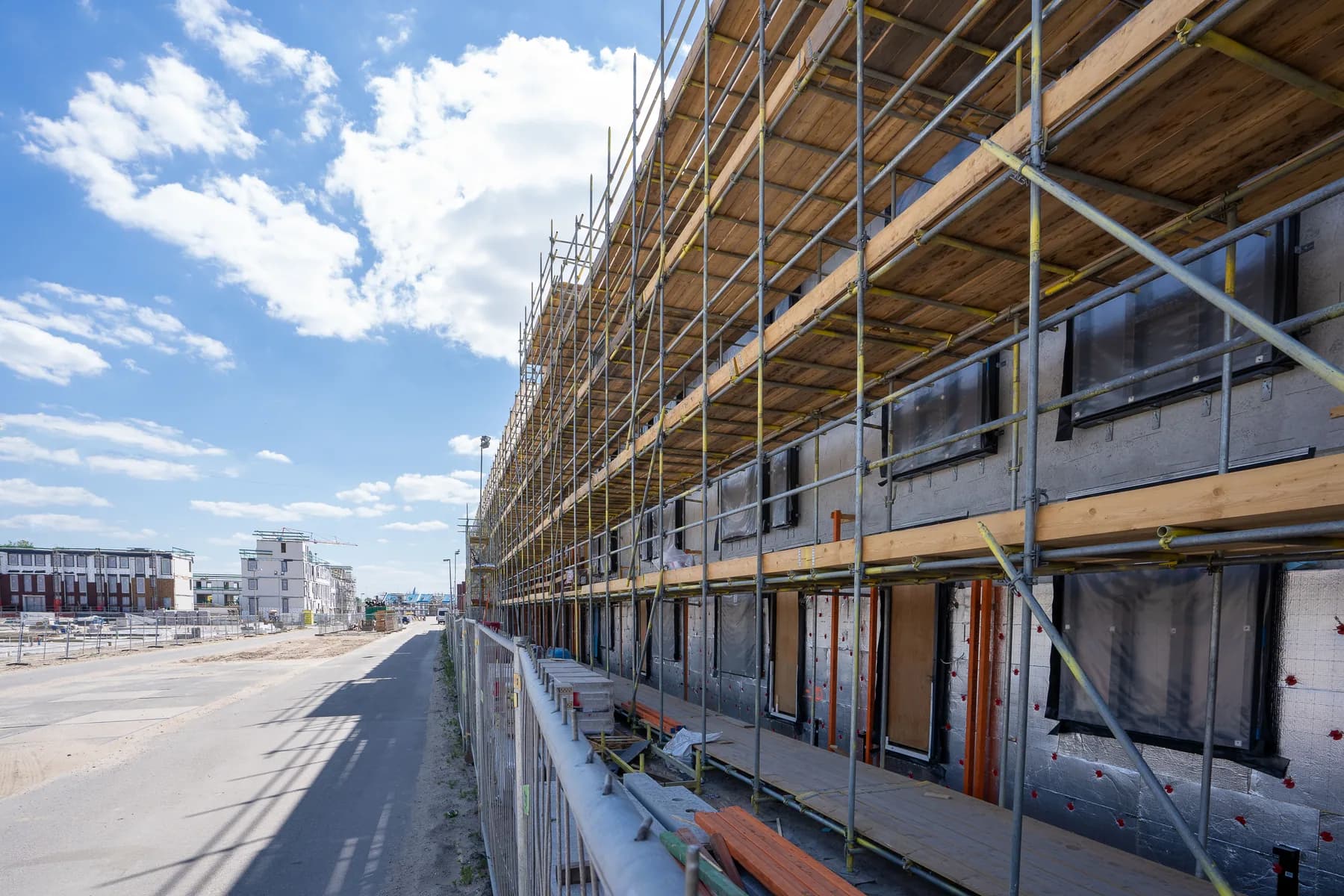 Building under construction with yellow scaffolding